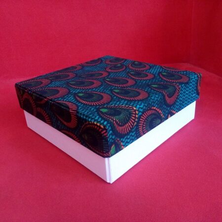 Present your gifts in style with our Gift Box featuring a Kitenge top and white button Ankara design. Perfect for adding a unique African touch to your gift-giving, this beautifully crafted box is ideal for special occasions. Elevate your gifting experience with this vibrant, handcrafted design. Order now!